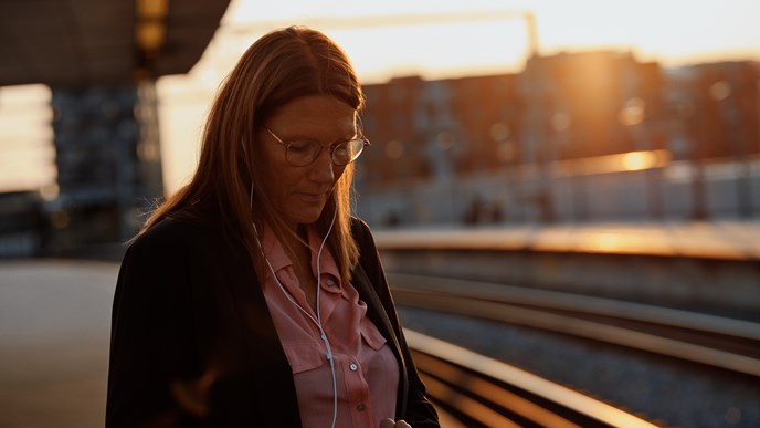 En kvinde tjekker sin pension, mens hun venter på toget