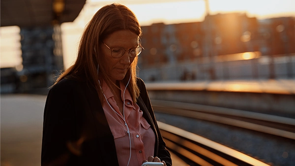 Kvinde på togstation med Mobil