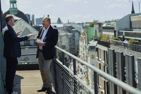 To pensionsrådgivere fører en samtale på en altan i indre by